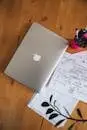 A home office desk with a laptop, papers, and a pen holder, ideal for remote work.